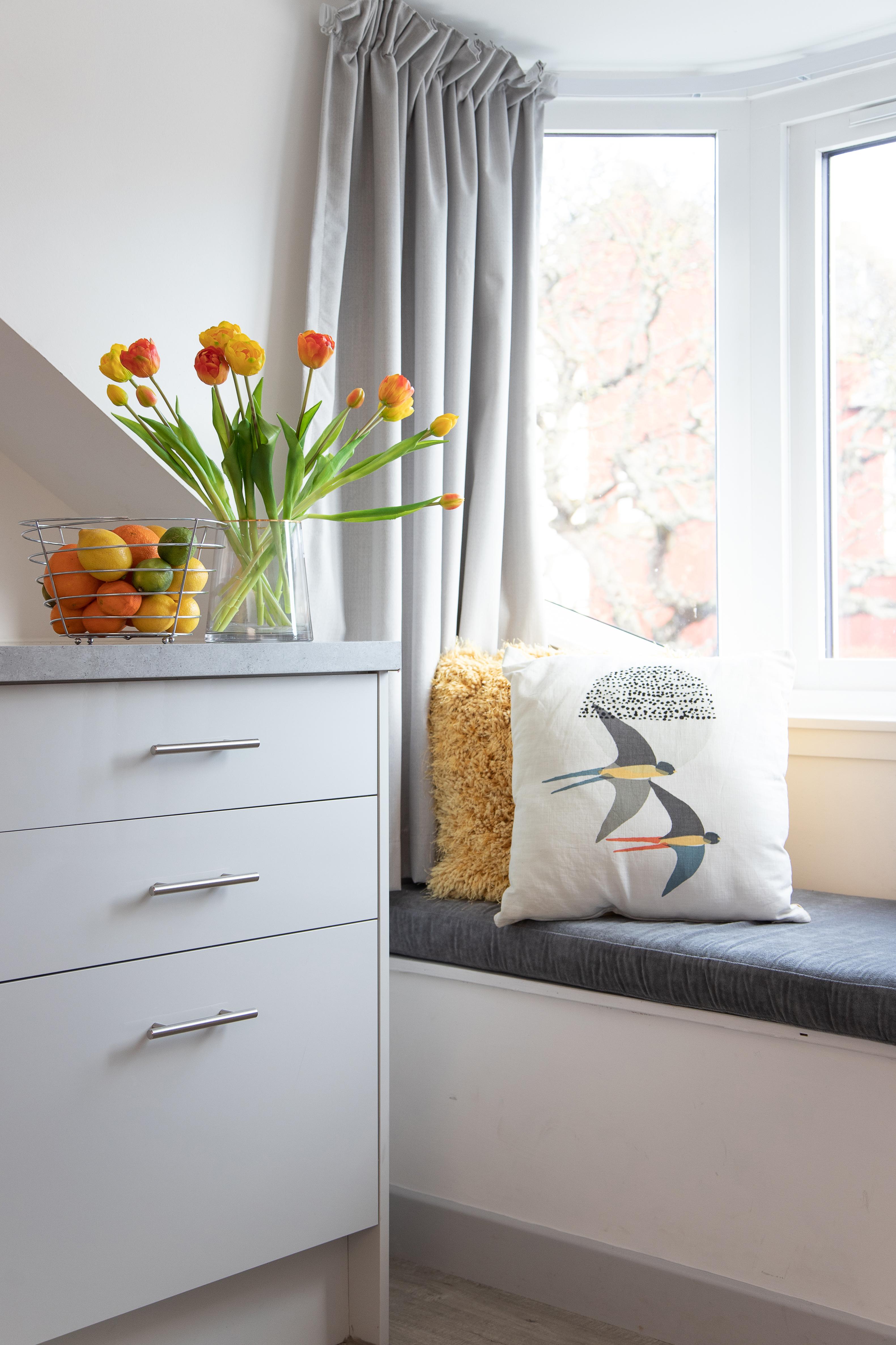 Sunny window nook with cozy seating and fresh, modern touches