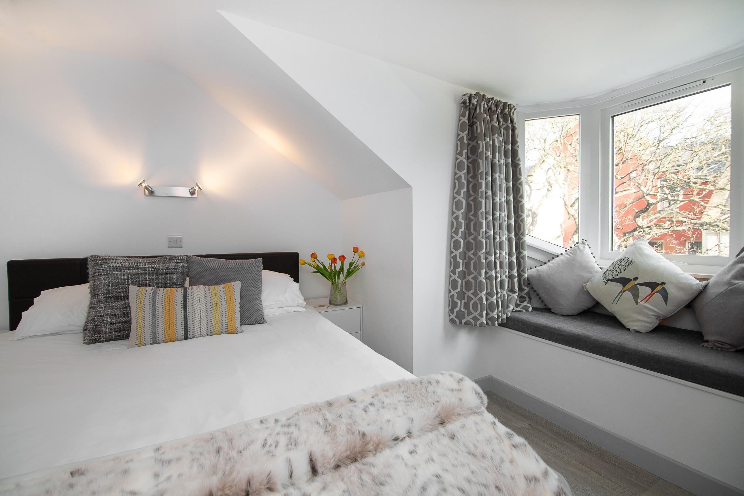 Bright cozy bedroom with window seat and lovely natural light