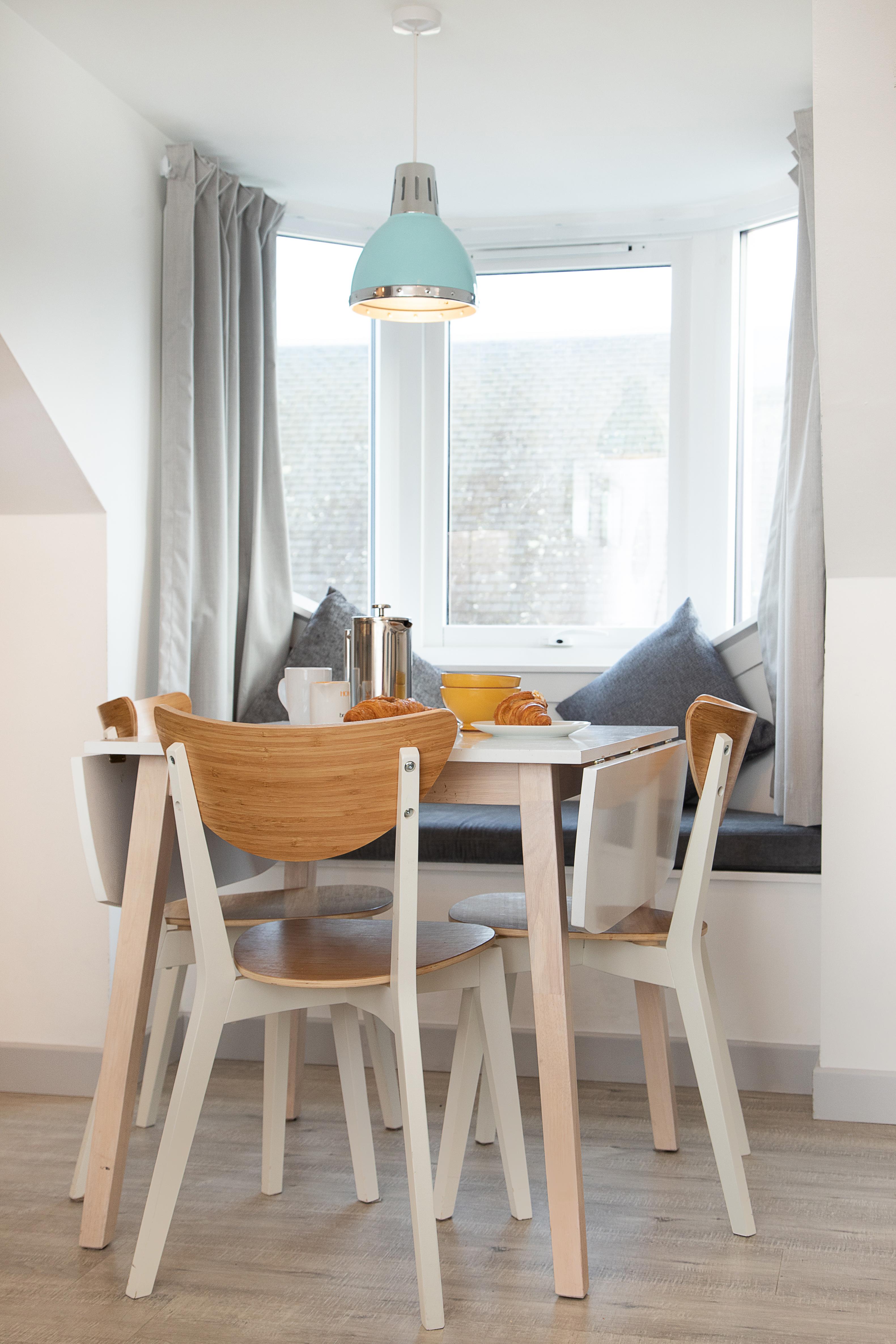 Bright window-side dining nook with cozy bench seating and modern style
